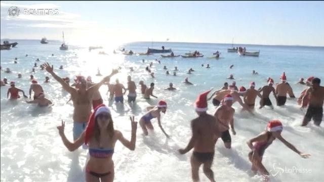 Il gelido tuffo dei Babbi Natale in bikini