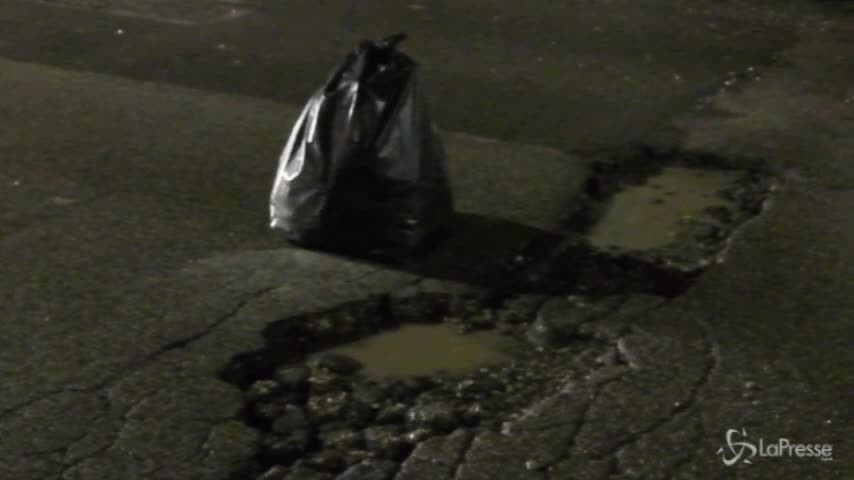 Roma: la spazzatura delimita le buche per strada
