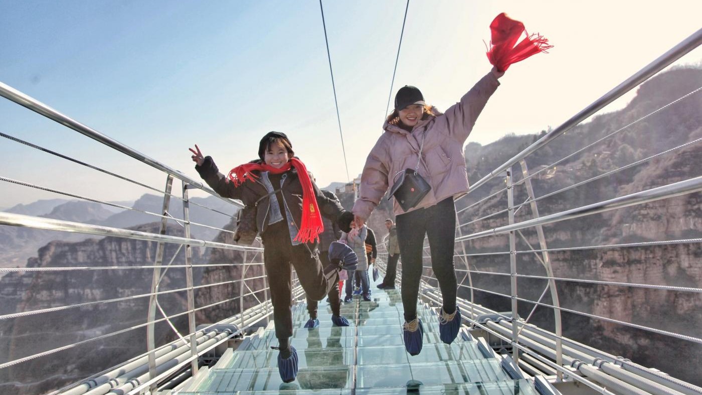 Insolita passeggiata in Cina: turisti sul ponte sospeso a Pingshan