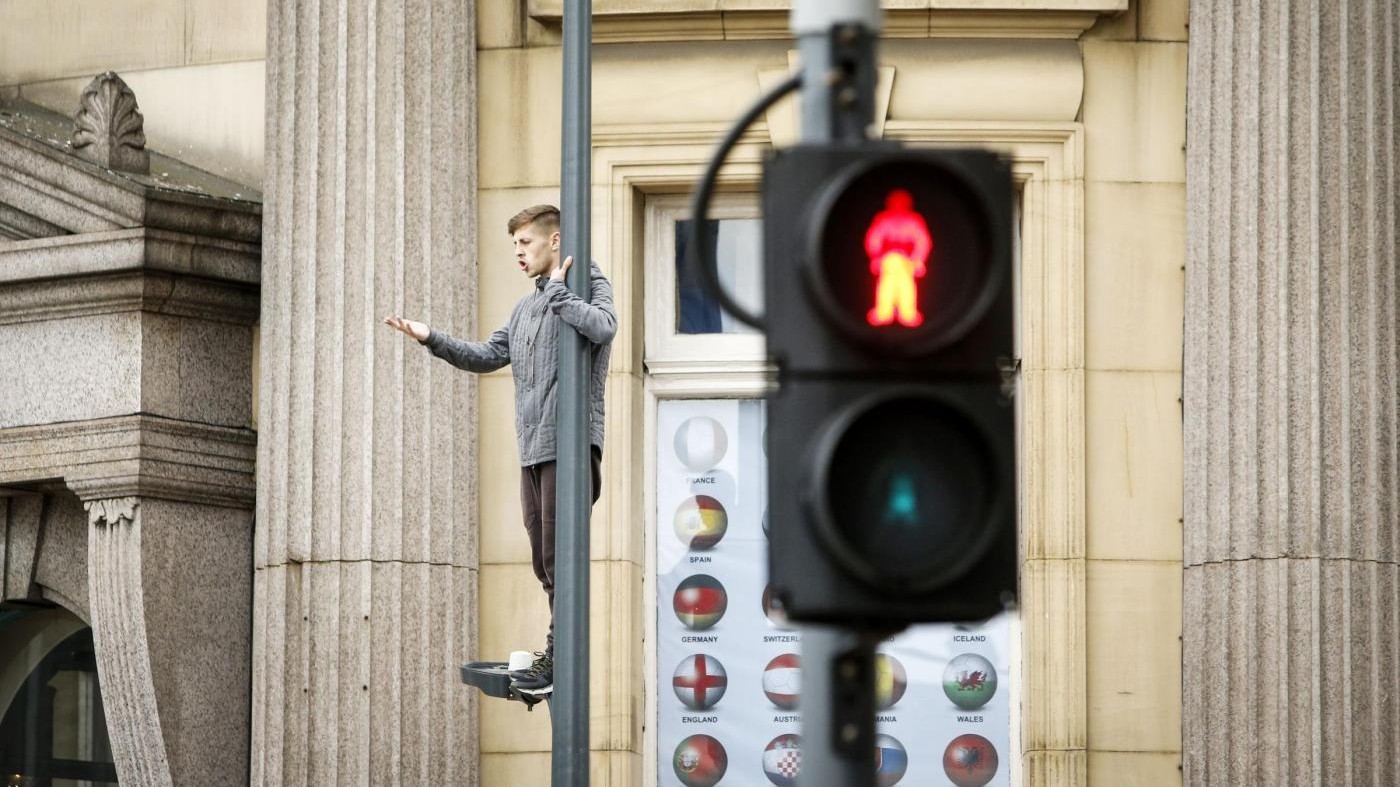 FOTO Uomo si arrampica sul lampione e paralizza il traffico