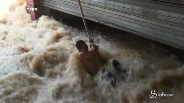 Cina: l’acqua lo blocca in un parcheggio, il salvataggio è estremo
