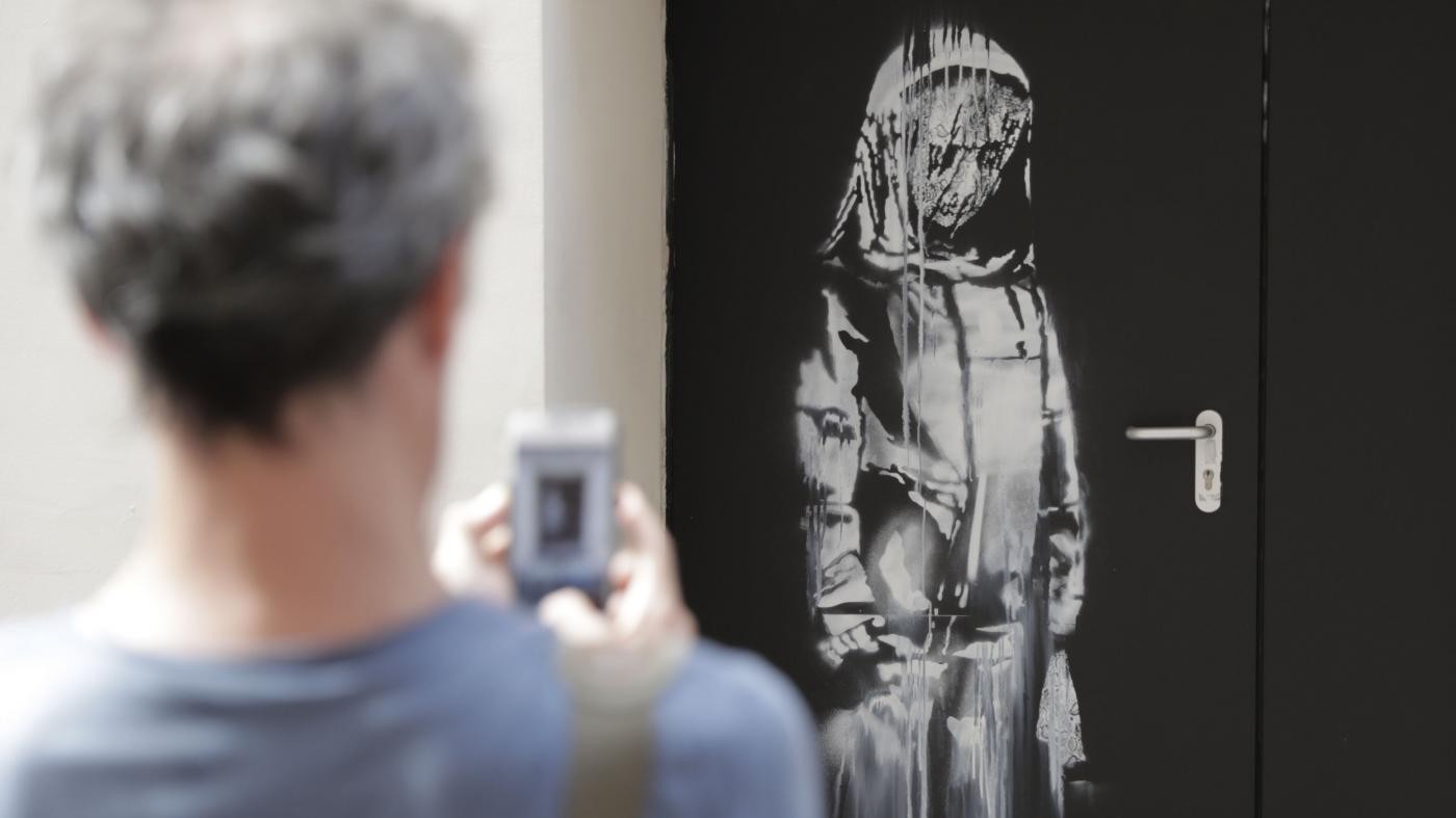 Dal Bataclan al centro accoglienza: Banksy dipinge sui muri di Parigi