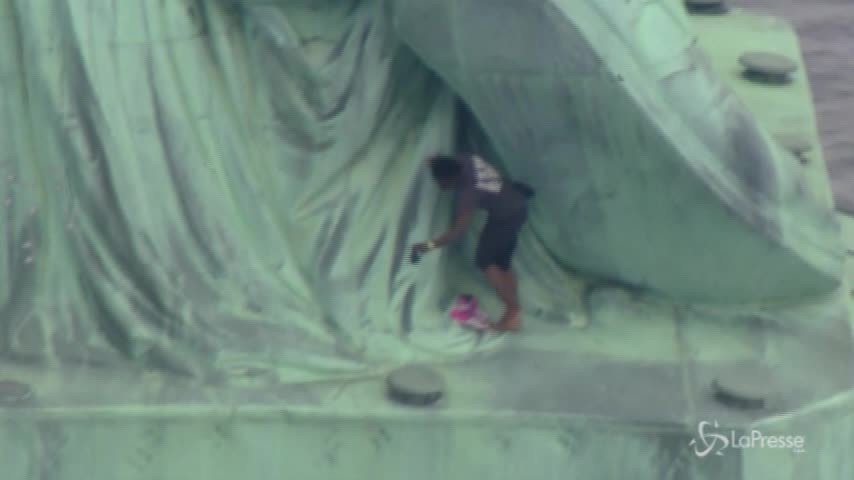 Si arrampica sulla Statua della Libertà: “Trump liberi i bambini migranti”