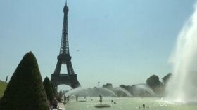Caldo, i parigini si rinfrescano davanti alla Torre Eiffel