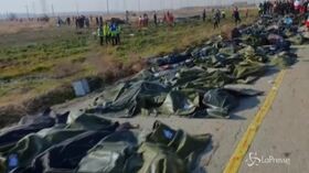 Iran, aereo caduto: i corpi in fila sul luogo del disastro