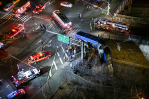A NY bus hangs off from expressway in the Bronx