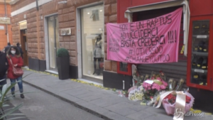 Fiori e uno striscione davanti al negozio di Clara