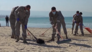 Volontari puliscono le spiagge dopo lo sversamento di petrolio