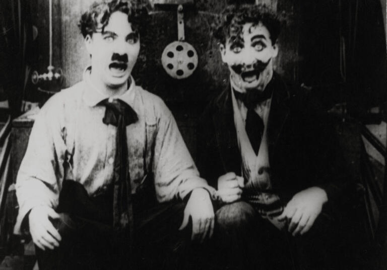Charlie Chaplin in una scena del film "Charlot pompiere"