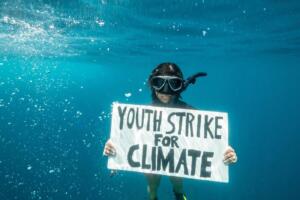 Sciopero per il clima, attivista Fridays for Future protesta sott’acqua con Greenpeace