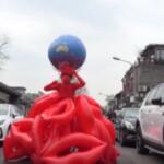 Giornata della Terra: artista cinese indossa palloncini a forma di bacio e mappamondo come corona