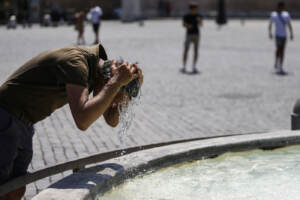 Caldo a Roma, i pochi turisti si rinfrescano nelle fontane
