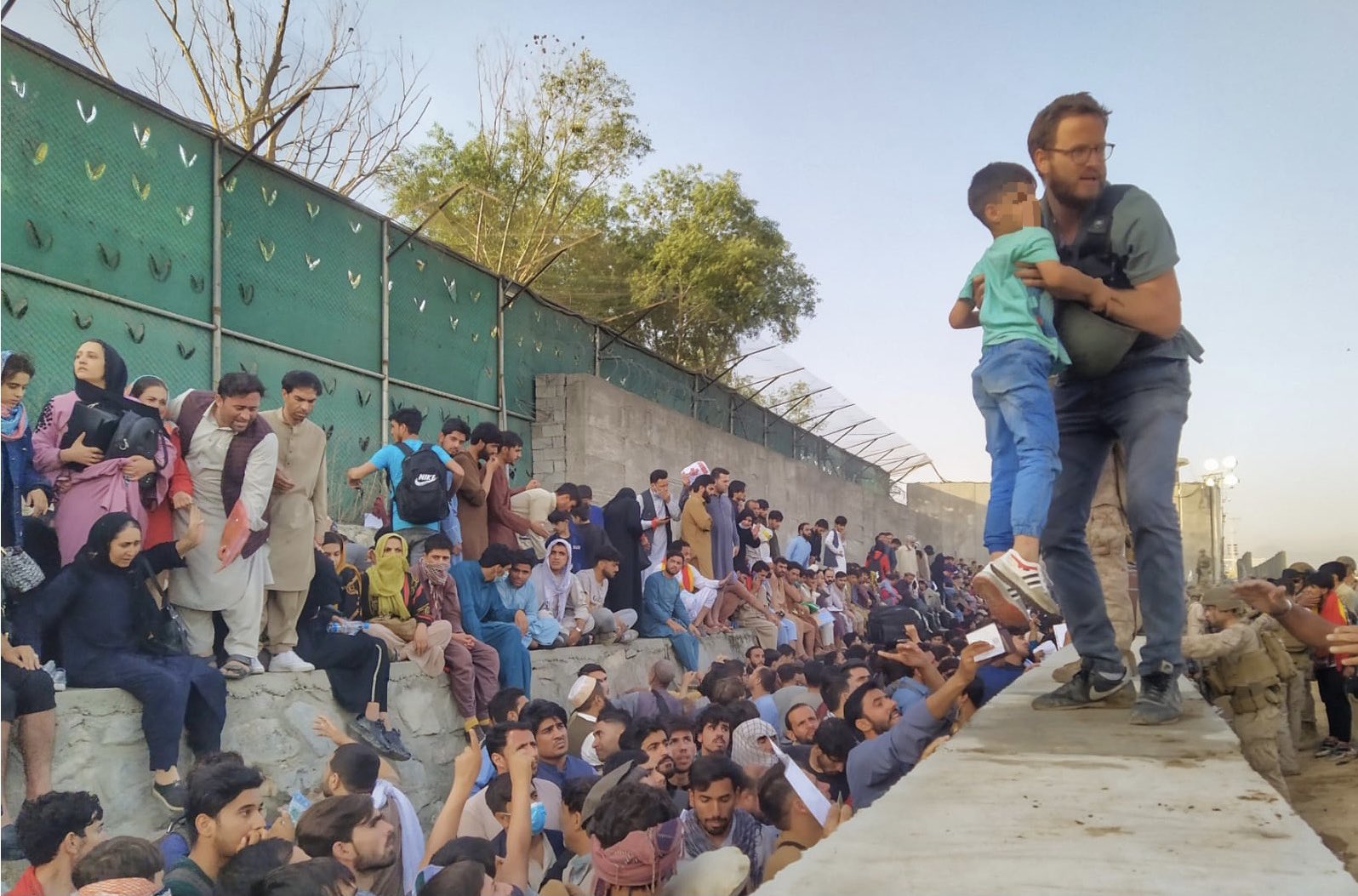 Il console Tommaso Claudi aiuta un bambino afghano all’aeroporto di Kabul