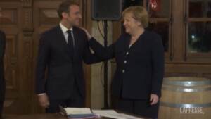 La Francia omaggia Angela Merkel, l’abbraccio affettuoso con Macron
