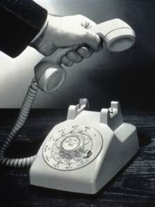 PARTICOLARE DI MANO CHE ALZA LA CORNETTA DEL TELEFONO