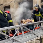 Ucraina: a Kiev colpito palazzo residenziale, nel video il salvataggio di una donna anziana