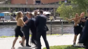Germania, le attiviste Femen si spogliano davanti a Scholz e lo contestano: “Basta soldi a Putin”