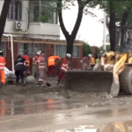 Alluvione in Cina, cittadini spalano fango a Pechino
