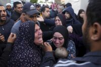 Palestinesi soccorrono i sopravvissuti dopo un attacco israeliano a Rafah, Striscia di Gaza
