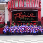 Parigi 2024, la torcia olimpica davanti al Moulin Rouge