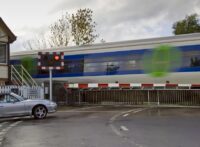 CAR WAITS AT RAILWAY CROSSING IN ASCOTT-UNDER-WYCHWOOD