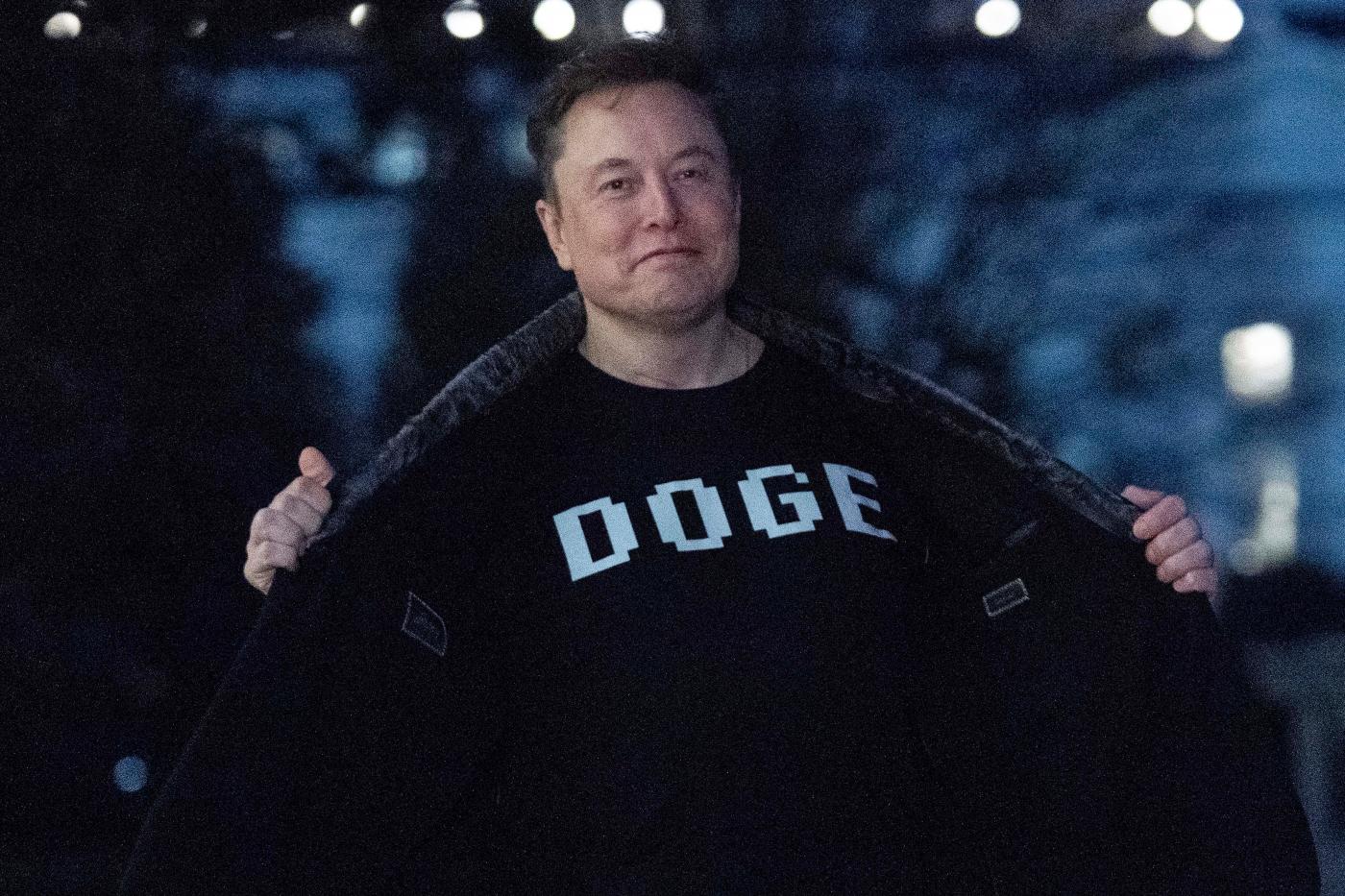 Elon Musk mostra alla stampa la tshirt con la scritta DOGE