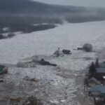 Russia, inondazioni dopo lo scioglimento dei ghiacci: le persone camminano con l’acqua a mezzobusto