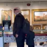 Julian Assange con il figlio in un negozio di souvenir