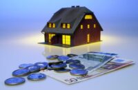 Immagine con una casa e dei soldi, a simboleggiare i mutui