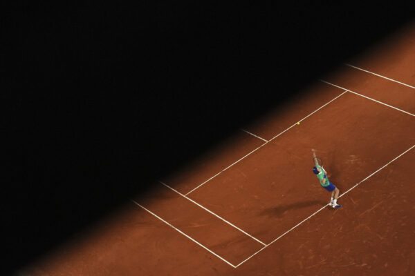 Un'immagine di Jannik Sinner in campo al Roland Garros 2025, intento in un servizio nella sua partita di primo turno contro Rinderknech