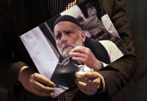 Padre Paolo dall'Oglio in una foto tenuta in mano da una persona in una manifestazione