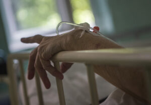 La mano di un anziano in un ospedale. In Toscana una 55enne paralizzata ha chiesto a un tribunale di poter accedere all'eutanasia perché non è in grado di somministrarsi autonomamente il farmaco per il suicidio assistito. Il caso è andato alla Corte Costituzionale