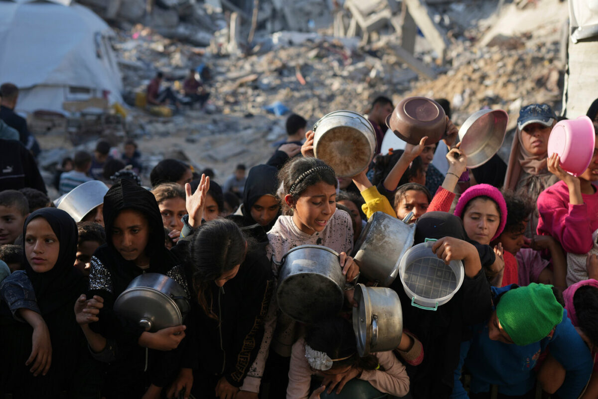 Palestinesi lottano per il cibo donato in un centro di distribuzione a Beit Lahiya nella Striscia di Gaza.