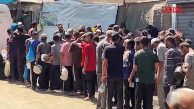 Gaza, decine di palestinesi in fila per un piatto di riso: le immagini da Deir Al-Balah