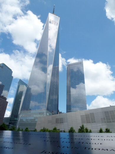 Le nuvole si riflettono sulla facciata in vetro del One World Trade Center (1° WTC) davanti al memoriale dell'11 settembre costruito sul sito noto come Ground Zero, dove sorgevano le Torri Gemelle