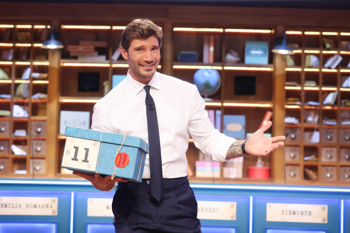 Affari tuoi, la gag con il jingle della Ruota della Fortuna: De Martino saluta i ‘dirimpettai’