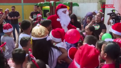 Venezuela, giornalisti vestiti da Babbo Natale portano regali ai bambini poveri di Caracas
