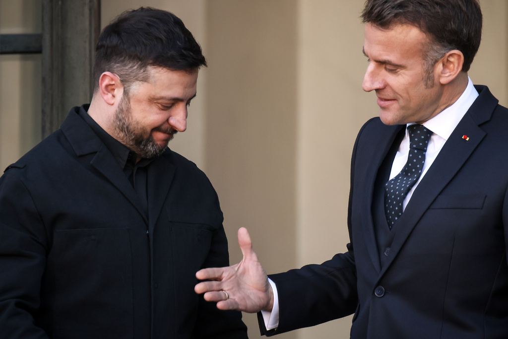 Il presidente ucraino Volodymyr Zelensky accolto dal leader francese Emmanuel Macron prima della riunione dei Volenterosi del 6 gennaio 2026 (foto Ap/Thomas Padilla)