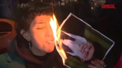 Germania, manifestanti iraniani si accendono una sigaretta usando la foto di Khamenei
