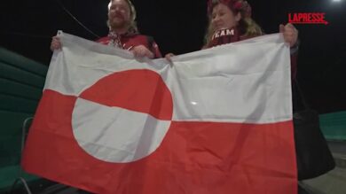 Olimpiadi 2026, due tifosi lettoni sventolano la bandiera della Groenlandia alla partita di hockey