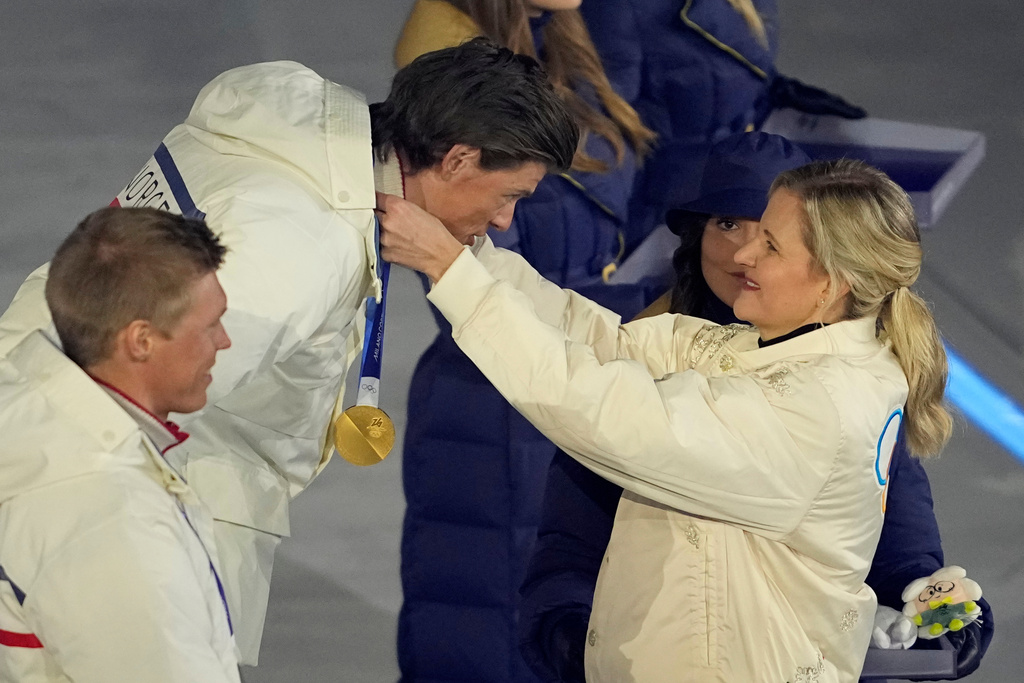 La presidente del CIO Kirsty Coventry consegna a Johannes Hoesflot Klaebo la medaglia d'oro durante la premiazione della gara di sci di fondo maschile 50 km (AP Photo/Ashley Landis)