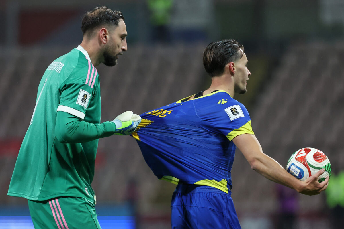 Gianluigi Donnarumma trattiene la maglietta di Amar Dedic. (AP Photo/Armin Durgut)