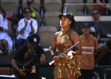 Una volta tolti bomber e strascico, Naomi Osaka rivela un abito da gara tempestato di paillettes dorate che partono dal corpetto e finiscono sulla gonna. (Kyodo via AP Images)