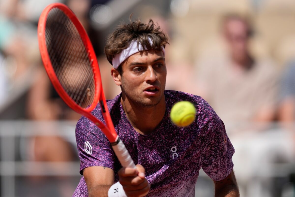 Flavio Cobolli impegnato contro un avversario durante una delle partite del suo percorso al Roland Garros 2026. (AP Photo/Christophe Ena)
