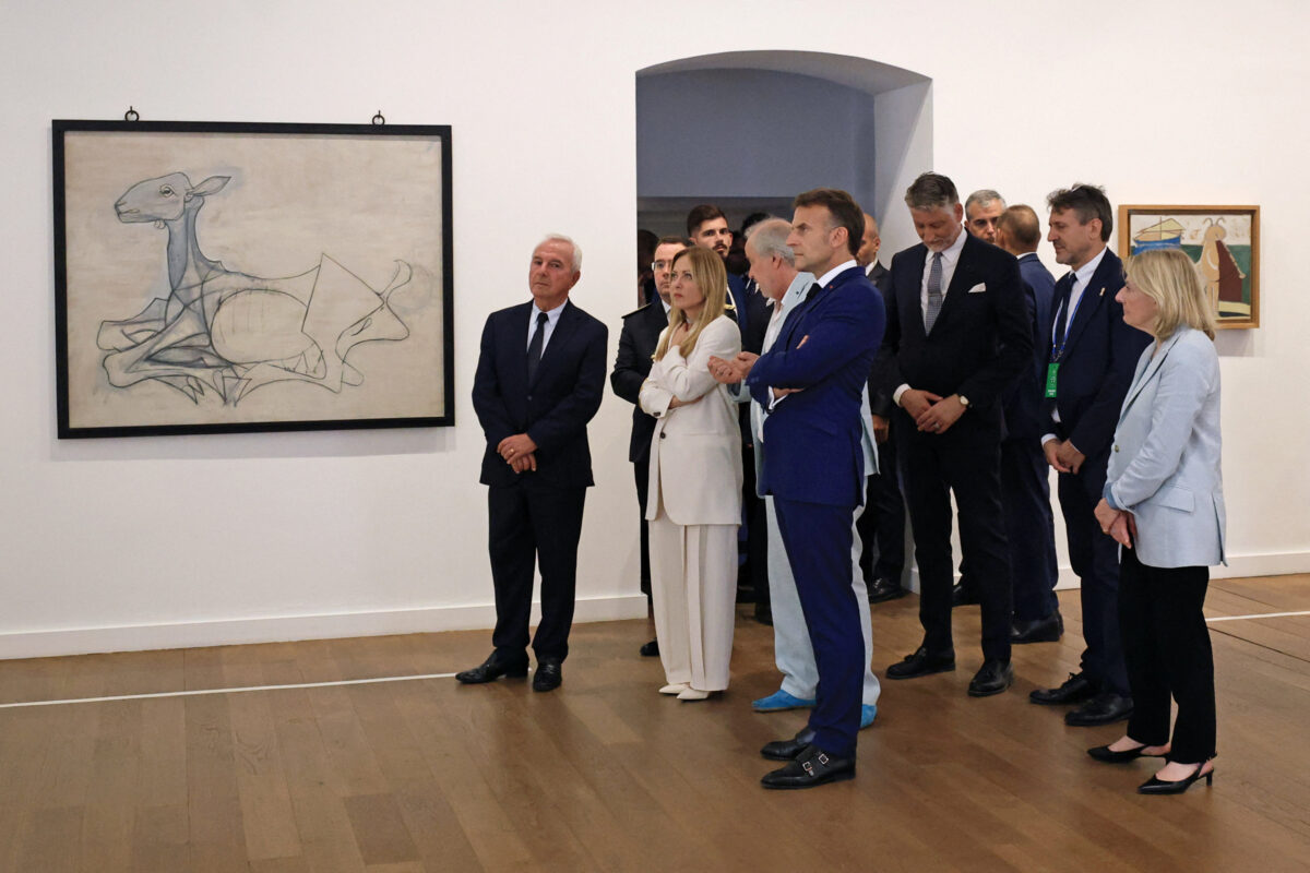 Il presidente francese Emmanuel Macron e il primo ministro italiano Giorgia Meloni, insieme alle rispettive delegazioni, ascoltano le spiegazioni durante una visita al Museo Picasso nell’ambito del vertice franco-italiano tenutosi ad Antibes, nel sud della Francia, giovedì 25 giugno 2026. (Manon Cruz/Pool Photo via AP)
