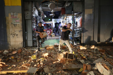 Alcuni uomini camminano tra le macerie dopo un terremoto a Caracas, in Venezuela, mercoledì 24 giugno 2026. (AP Photo/Pedro Mattey)
