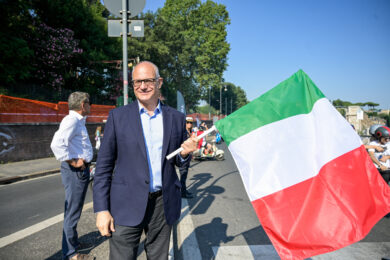Il sindaco di Roma, Roberto Gualtieri, con il tricolore tra le mani in attesa del passaggio delle Vespe. (Foto: Valentina Stefanelli/LaPresse)