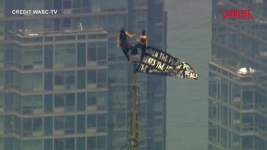 New York, due persone in cima a Empire State Building con striscione per l’amore e la pace. Le immagini dall’elicottero