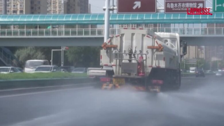 Caldo in Cina, camion spruzzano acqua sulle strade nella città di Urumqi