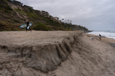 Le spiagge della California si stanno progressivamente restringendo . Un surfista risale un ripido pendio sabbioso a North Beach, a San Clemente (California) (Foto AP/Jae C. Hong)